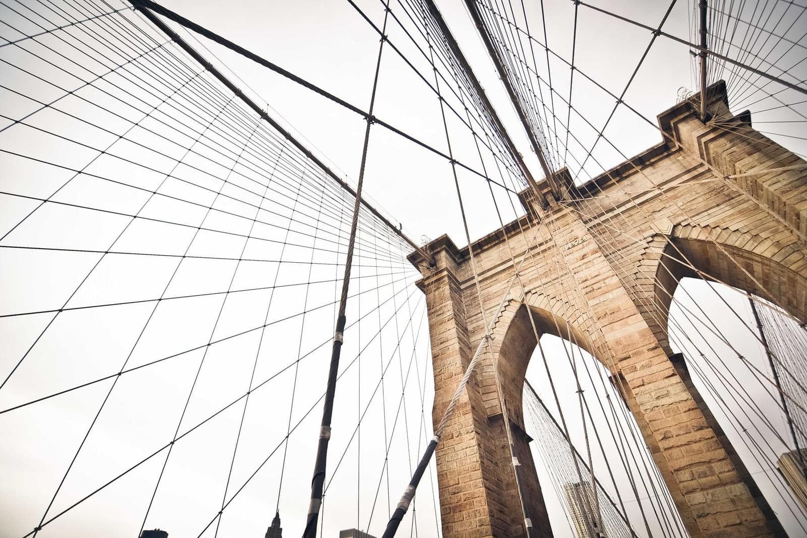 The cables of a suspension bridge against the sky.