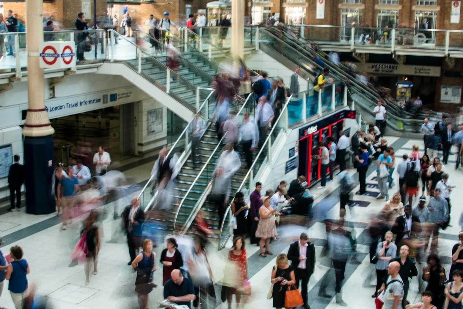 Commuters on escalators in a busy station.