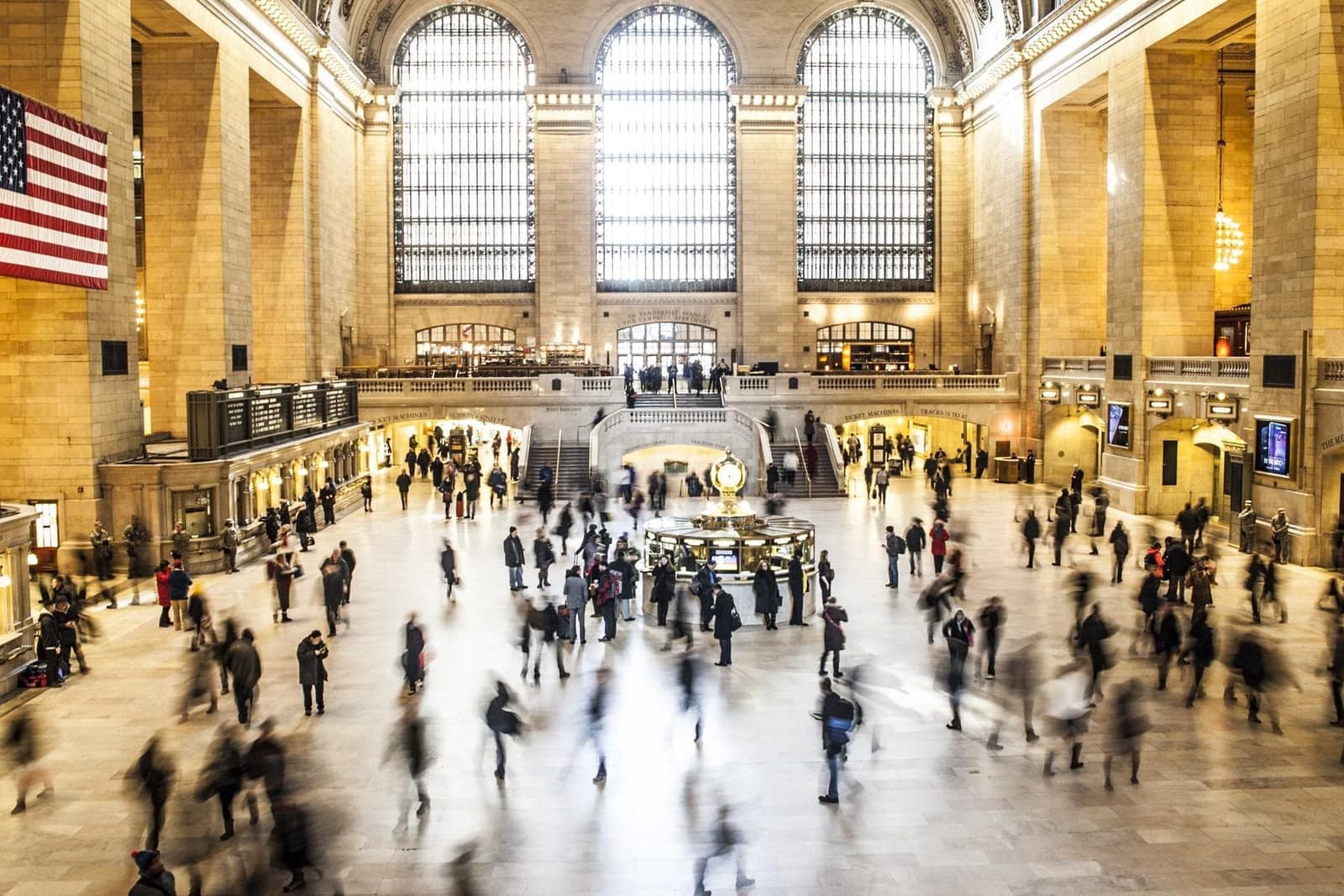 A busy station hall with people crossing it.