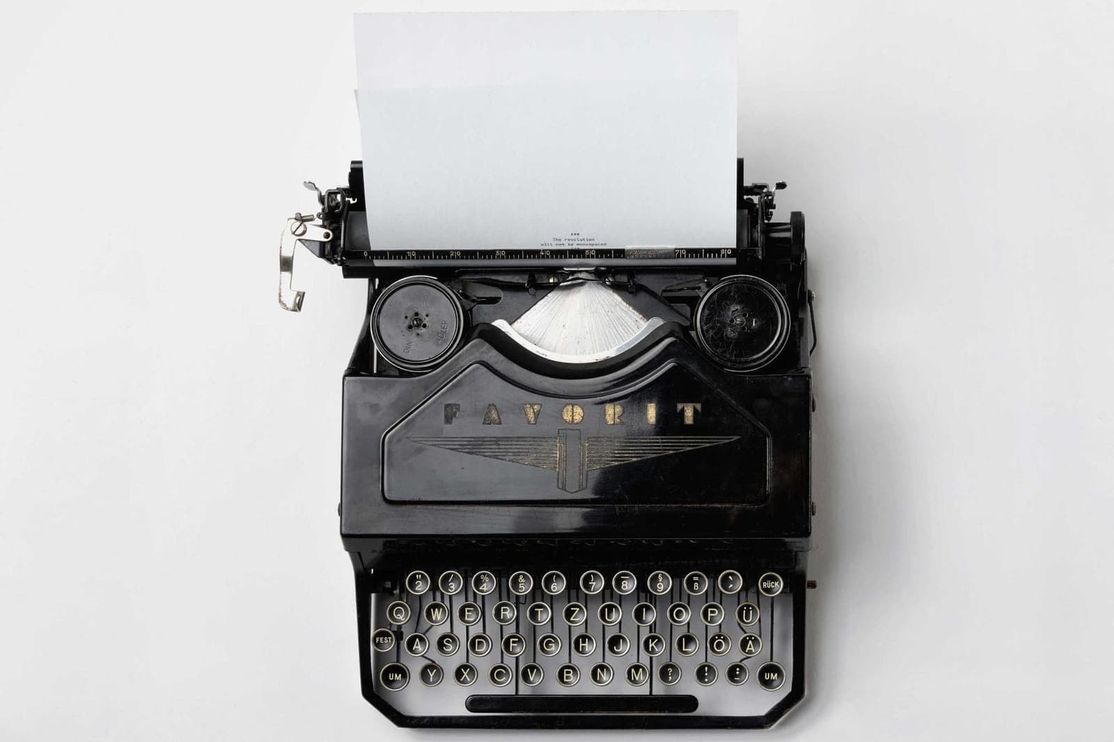 A typewriter on a white desk.