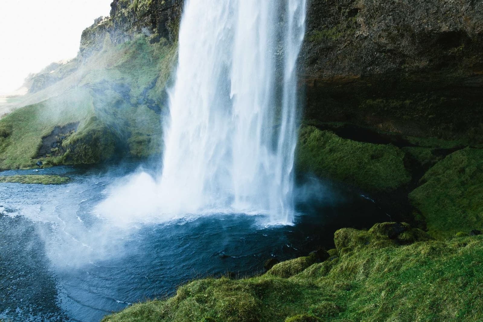 A waterfall pouring into a green valley.
