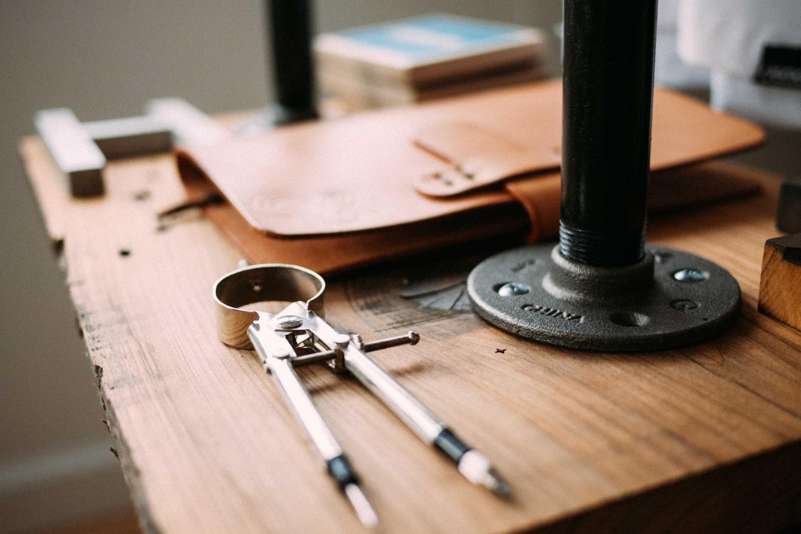 A workbench with leather, a compass and tools.